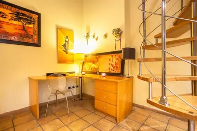 a home office with a desk and a staircase at Il Nido -Cinema HD & Relax Space in Rome