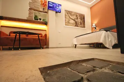 a living room with a bed and a tv at Domus Grottae at Campo de fiori in Rome