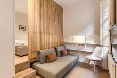 a living room with a couch and a bed at Domus Romano Piazza Farnese in Rome