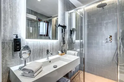 a white bathroom with a sink and a shower at Domus Romano Piazza Farnese in Rome