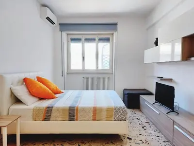 a bedroom with a bed with orange pillows and a television at Luminoso a due passi da Trastevere in Rome