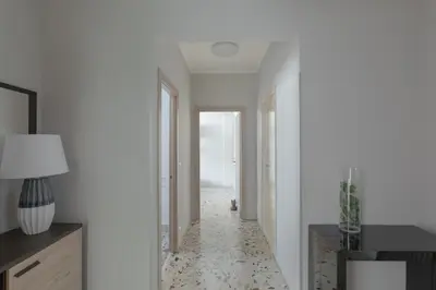a hallway with white walls and a floor with a patterned floor at Luminoso a due passi da Trastevere in Rome