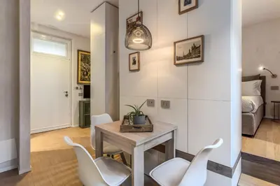 a dining room with a table and white chairs at Domus Romano Campo de Fiori in Rome