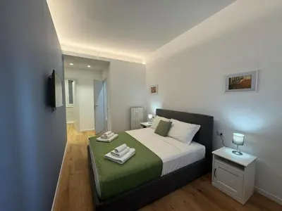 a bedroom with a bed with a green and white blanket at Roman Pearl in Portuense in Rome