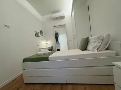 a white bedroom with a bed and a mirror at Roman Pearl in Portuense in Rome