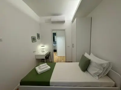 a white bedroom with a bed and a desk at Roman Pearl in Portuense in Rome