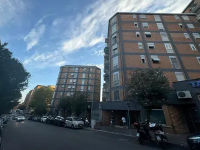 a city street with cars parked next to a tall building at Roman Pearl in Portuense in Rome