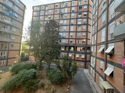 an apartment building with a tree in front of it at Roman Pearl in Portuense in Rome
