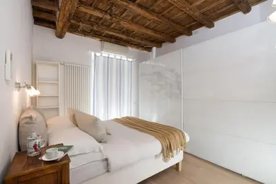 a white bedroom with a bed and a table at NEW! Design apartment 2 min from Spanish Steps in Rome
