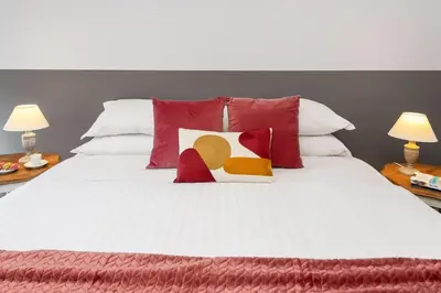 a bed with red and white pillows on it at Big Flat in the Heart of Trastevere 4 bedrooms 3 bath in Rome