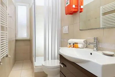 a bathroom with a white sink and a toilet at Big Flat in the Heart of Trastevere 4 bedrooms 3 bath in Rome