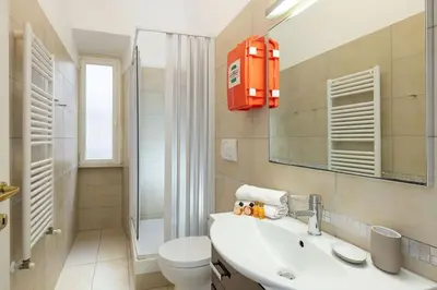 a bathroom with a sink and a toilet and a mirror at Big Flat in the Heart of Trastevere 4 bedrooms 3 bath in Rome