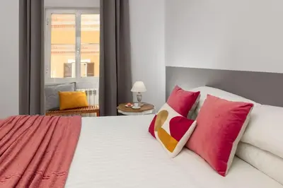a bedroom with a bed with red and pink pillows at Big Flat in the Heart of Trastevere 4 bedrooms 3 bath in Rome