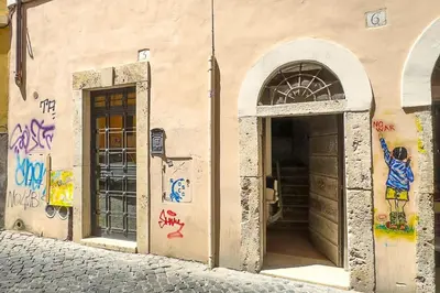 a building with graffiti on the side of it at ht vicolo 6 bilo in Rome