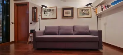 a couch sitting in a living room with two lamps at Er Core Nostro in Rome