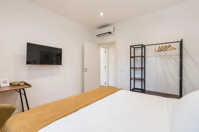 a bedroom with a bed and a tv on the wall at The Best Rent - Spacious three-bedroom apartment in Prati area in Rome