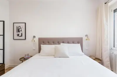 a white bedroom with a large bed and a window at The Best Rent - Spacious three-bedroom apartment in Prati area in Rome