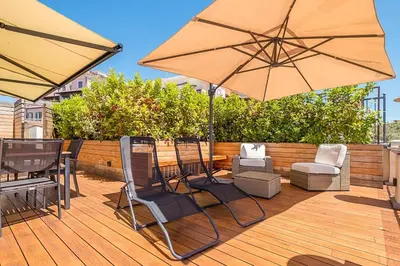 a patio with chairs and umbrellas on a deck at HT Borromini Penthouse in Rome
