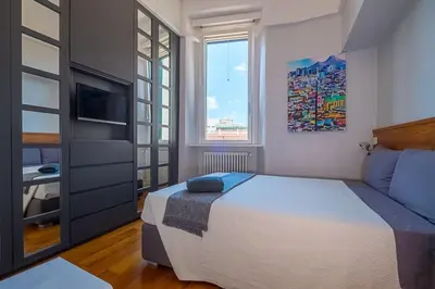 a bedroom with a large bed and a window at HT Borromini Penthouse in Rome