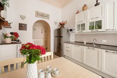 a kitchen with a table and a refrigerator at Stefano Soffici Domus Trastevere in Rome