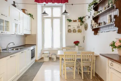 a kitchen with white cabinets and a table and chairs at Stefano Soffici Domus Trastevere in Rome