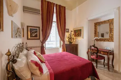 a bedroom with a red bed and a window at Stefano Soffici Domus Trastevere in Rome
