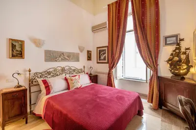 a bedroom with a bed with a red blanket at Stefano Soffici Domus Trastevere in Rome