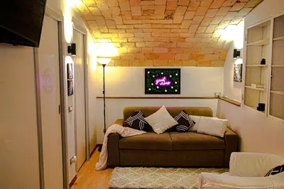 a living room with a couch and a tv on the wall at Eleganza e Confort nel Cuore dei Parioli in Rome