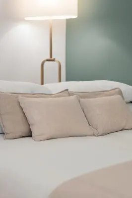 a white bed with pillows and a lamp on it at Emma Bliss Apartment in Rome