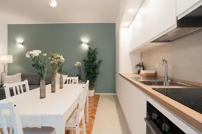 a kitchen with a white counter and a table with chairs at Emma Bliss Apartment in Rome