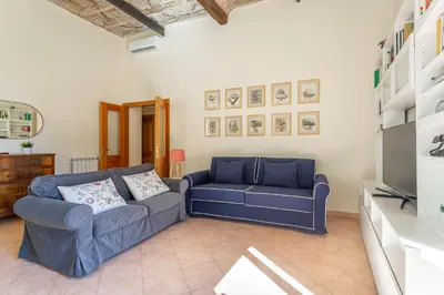 a living room with a blue couch and a tv at iFlat Space and Comfort in the Heart of Monti in Rome