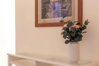 a vase with flowers in it sitting on a table at iFlat Space and Comfort in the Heart of Monti in Rome