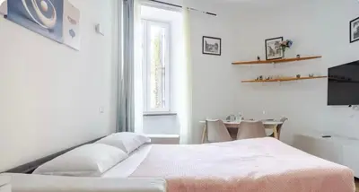 a white bedroom with a bed and a table at Trastevere Elite 