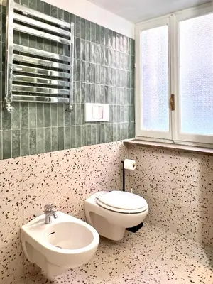 a bathroom with a white toilet and a sink at Trastevere Elite 