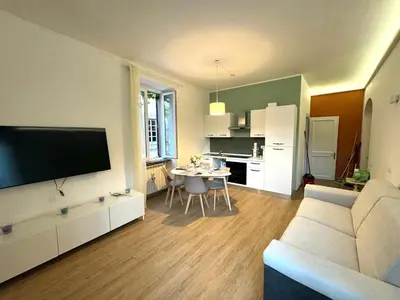 a living room with a white couch and a kitchen at Trastevere Elite 