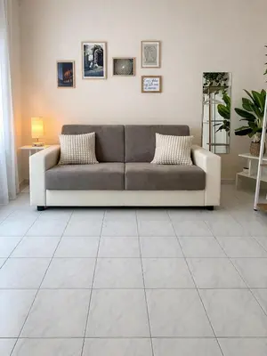 a lamp and a book on a nightstand next to a bed at 2BR Flat by Metro - 6min to Colosseo - Full Kitchen - Wi-Fi - A-C in Rome
