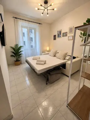 a bed in a room with a sign on the wall at 2BR Flat by Metro - 6min to Colosseo - Full Kitchen - Wi-Fi - A-C in Rome