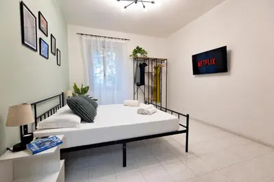a bedroom with a bed and a tv on a wall at 2BR Flat by Metro - 6min to Colosseo - Full Kitchen - Wi-Fi - A-C in Rome