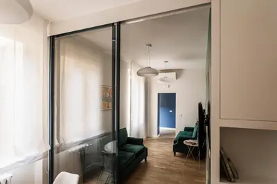 a living room with a green couch and a glass wall at Sant'Andrea Apartment in Rome