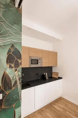 a kitchen with white cabinets and a painting on the wall at Sant'Andrea Apartment in Rome
