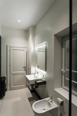 a bathroom with a sink and a toilet and a mirror at Sant'Andrea Apartment in Rome