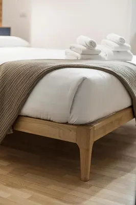 a bed with a white mattress on a wooden bed frame at Sant'Andrea Apartment in Rome