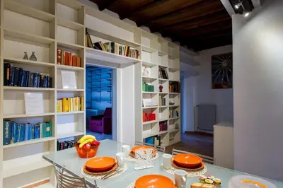 a dining room with a table and a book shelf at PANTHEON LARGE APARTMENT IN THE HEART OF ROME s in Rome