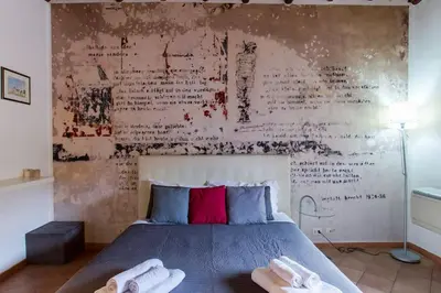 a bedroom with a bed with a wall with writing on it at PANTHEON LARGE APARTMENT IN THE HEART OF ROME s in Rome