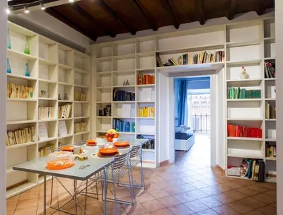 a dining room with a table and shelves with books at PANTHEON LARGE APARTMENT IN THE HEART OF ROME s in Rome