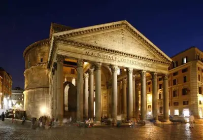 an ancient building with columns in a city at night at PANTHEON LARGE APARTMENT IN THE HEART OF ROME s in Rome