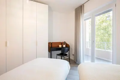 a bedroom with two beds and a desk with a window at Sky Luxury in Rome