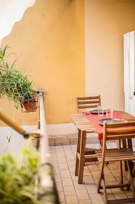 a table and chairs with a red table and a plant at Casa Broccoletti in Rome