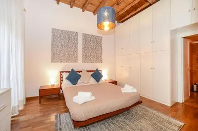 a bedroom with a large bed with blue pillows at PANTHEON 2 - LARGE APARTMENT IN THE HEARTH OF ROME a in Rome