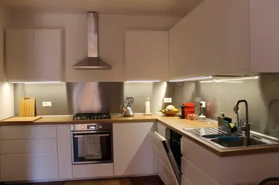 a kitchen with white cabinets and a sink at Casa Argia in Rome